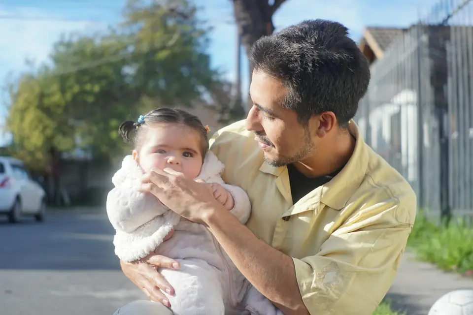 A father holding his baby up in the sunlight