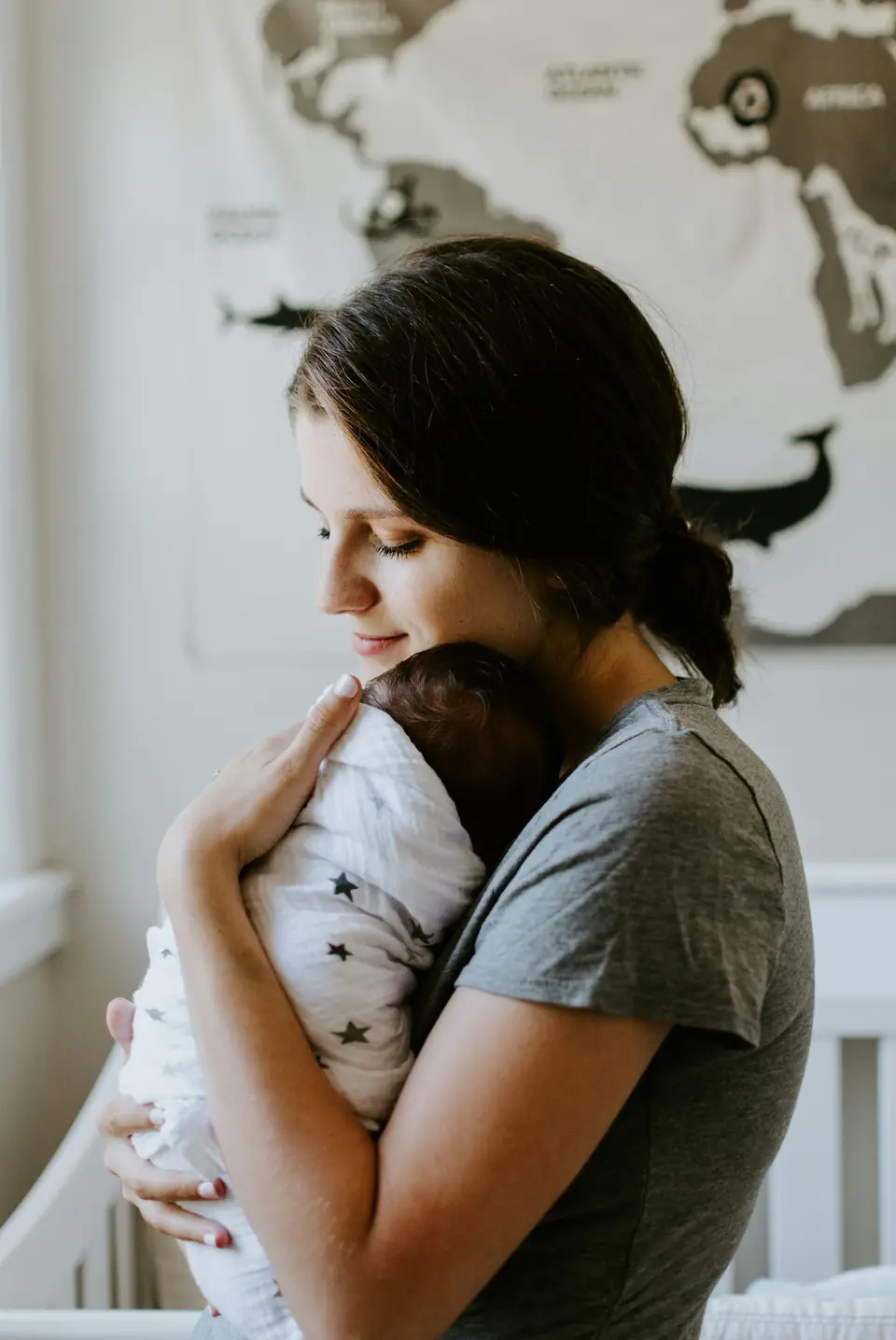 A woman holding a newborn close against her chest