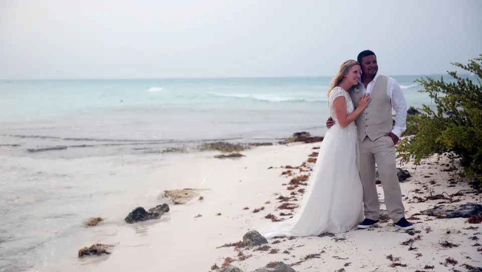 Bride and groom embracing on the beach